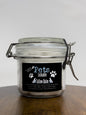 Jar of tallow balm for pets with a label on a wooden surface
